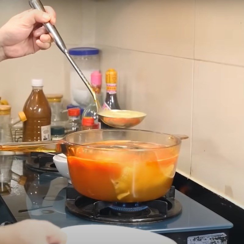 Cho phần cà chua múi cau vào nồi canh sau khi đã nêm nếm gia vị cơ bản