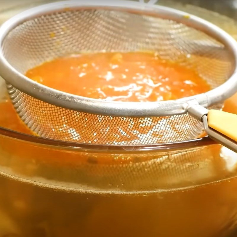 Dùng rây lọc hỗn hợp cà chua đã xào vào nồi nước canh cá