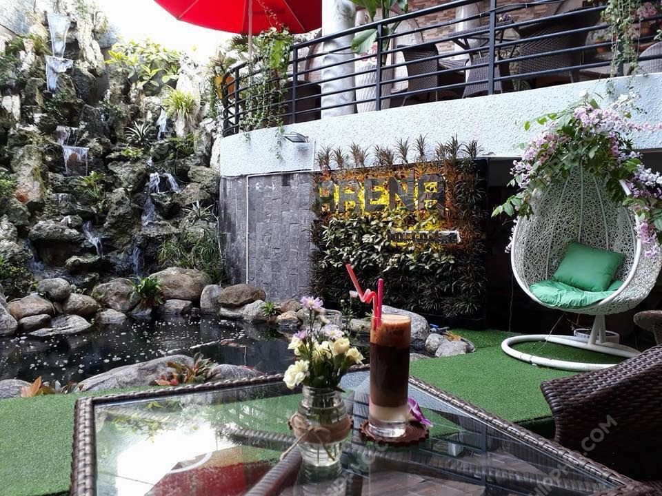 Góc thư giãn với cây xanh và hồ cá tại Arena Koi Coffee